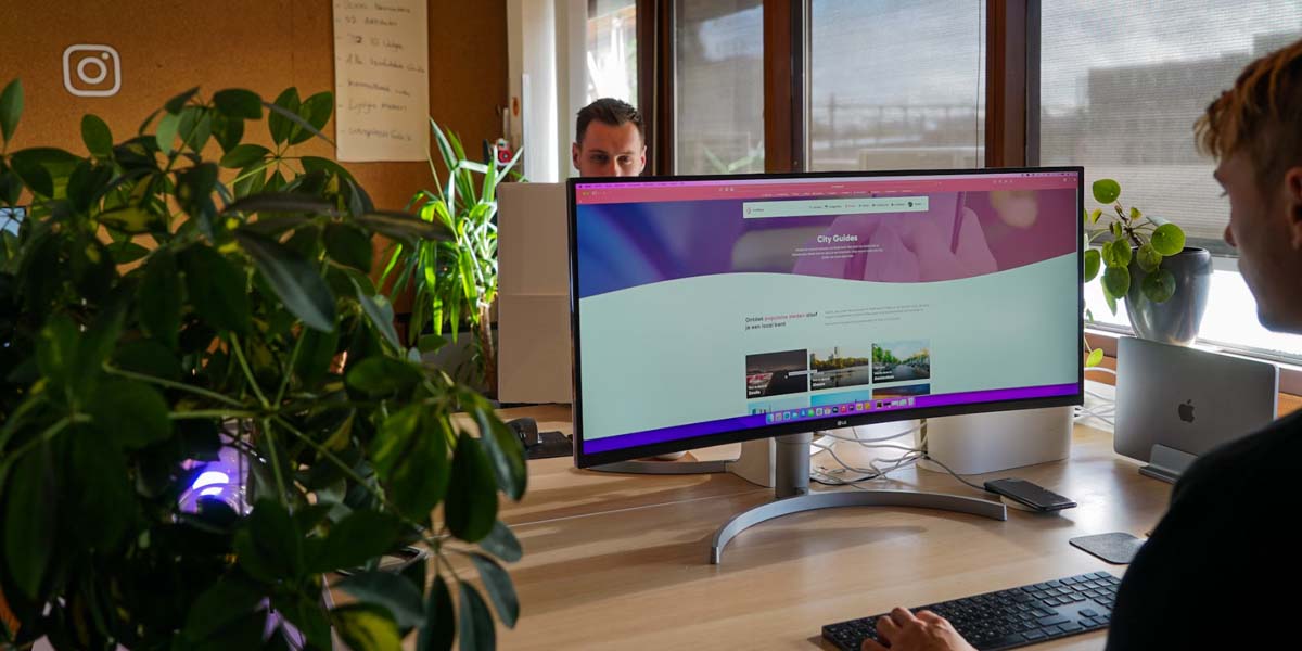 Two professionals working at computers in a modern office, representing streamlined IT operations with ServiceNow ITOM and CMDB